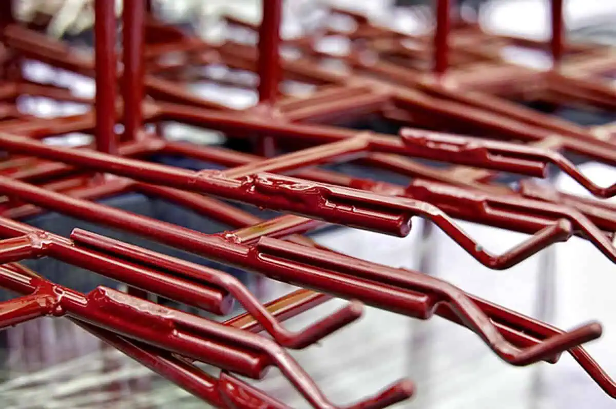 Red-coated metal parts for high capacity solutions, showcasing Carolina Chem Strip's services to keep your production smooth.