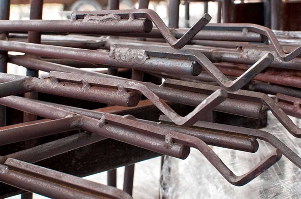 Rusty metal paint line fixtures, demonstrating high-capacity paint removal for line running efficiency.