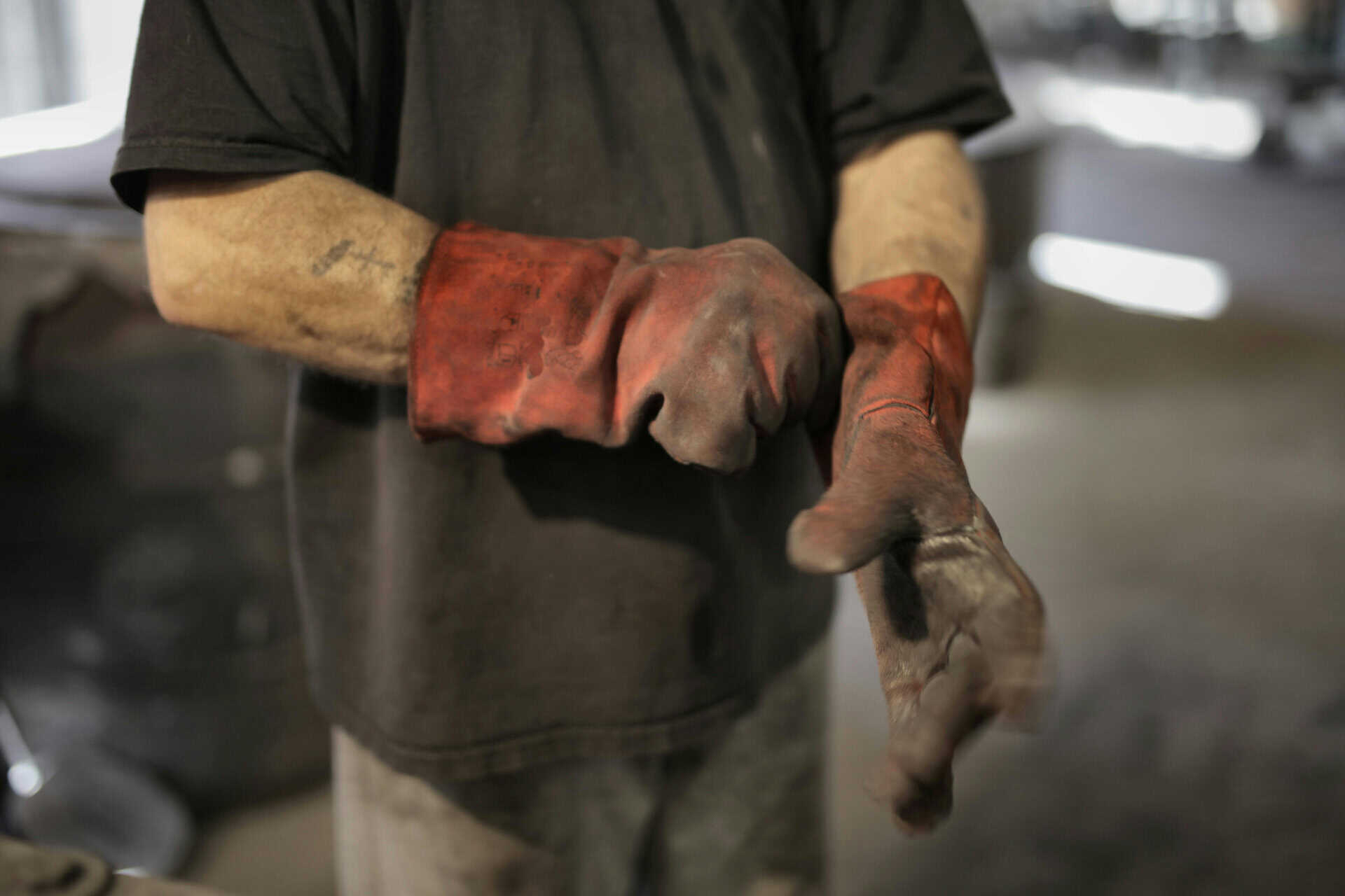Worker wearing protective gloves for fabrication amp repair of production-critical equipment.