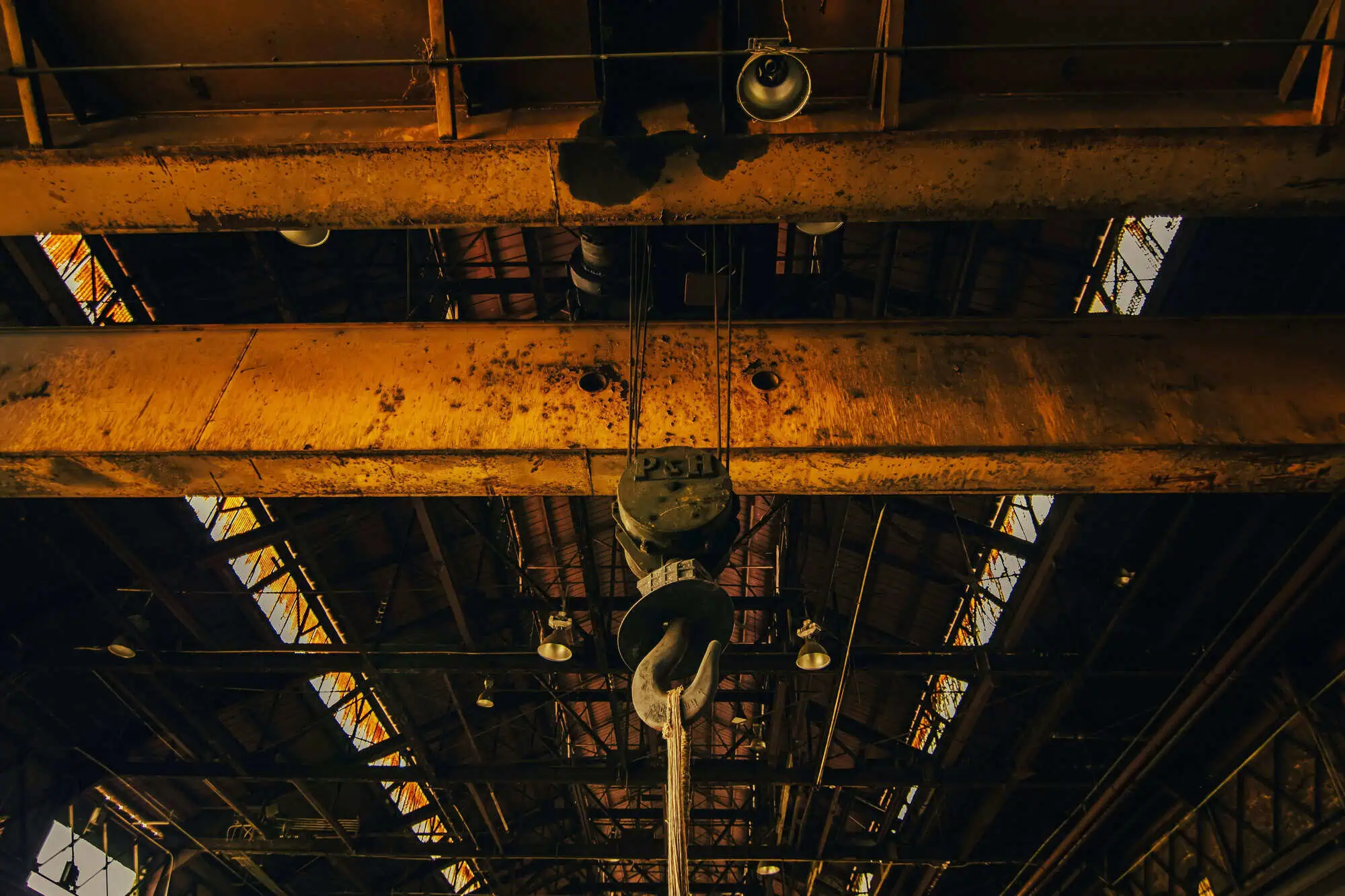 Industrial ceiling with a large hook used in fabrication amp repair, essential for production-critical equipment.