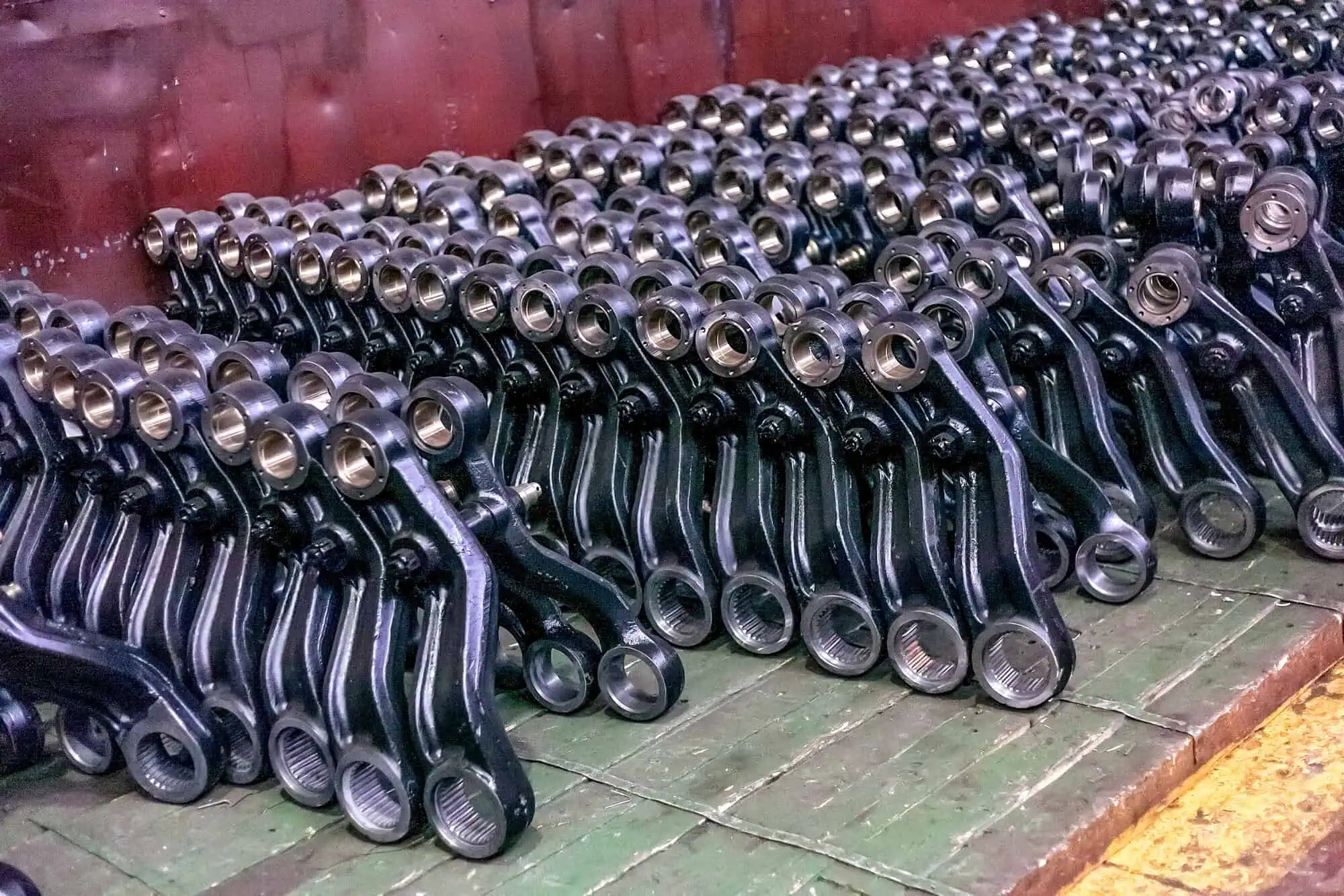Rows of industrial metal parts prepared for heavy-duty chemical stripping, key for rust removal services.