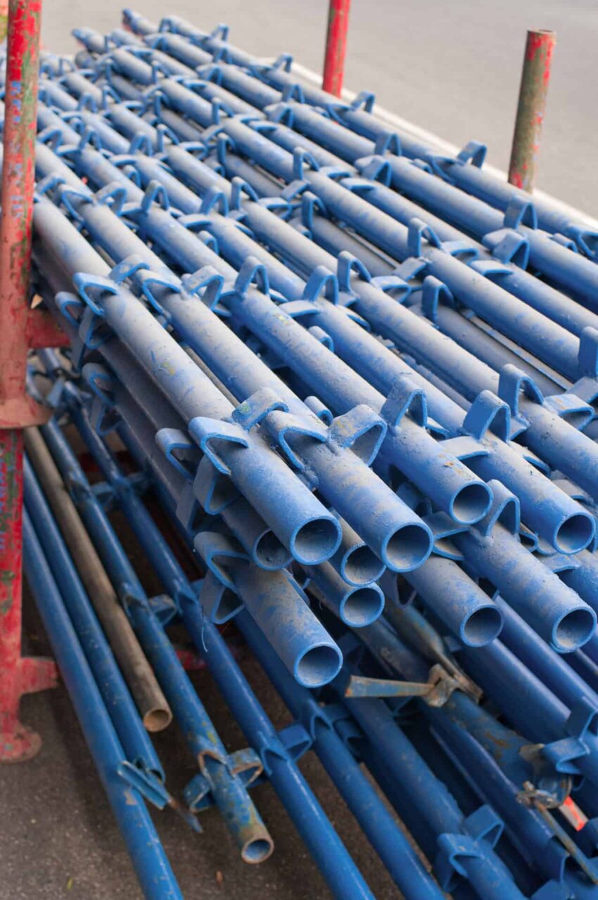 Blue metal paint line fixtures stacked, highlighting high-capacity paint removal for quality maintenance.