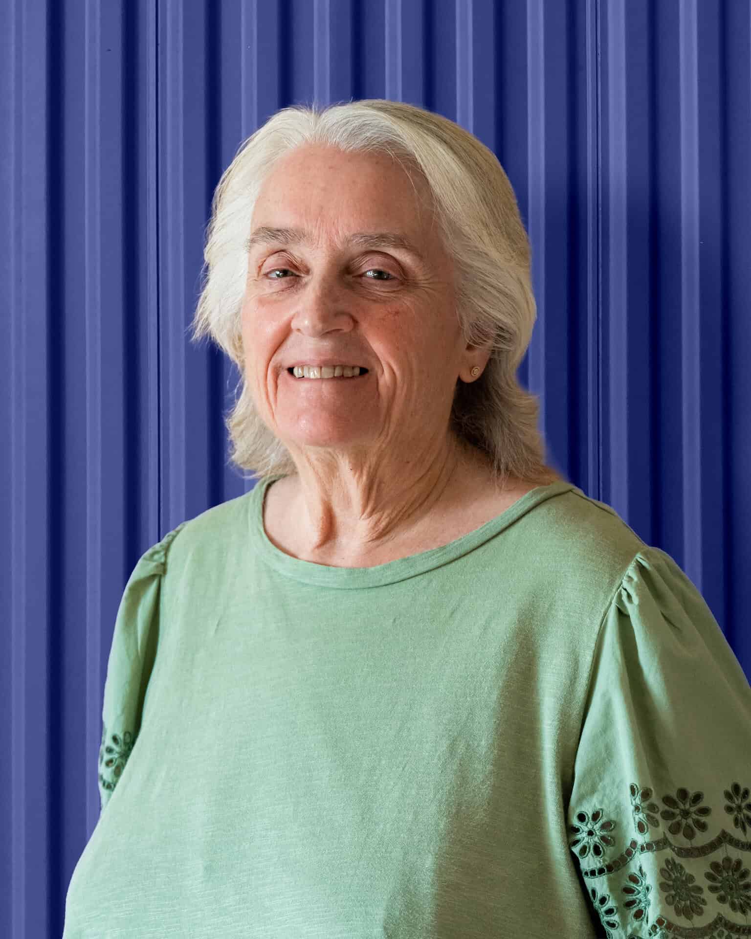 Team member of Carolina Chem Strip smiling against a blue background, emphasizing production support.